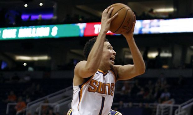 Phoenix Suns guard Devin Booker drives to the basket past Brisbane Bullets forward Daniel Kickert d...