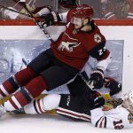Arizona Coyotes' Oliver Ekman-Larsson (23) and Chicago Blackhawks' Alex DeBrincat (12) both end up on the ice after colliding during the first period of an NHL hockey game Saturday, Oct. 21, 2017, in Glendale, Ariz. (AP Photo/Ross D. Franklin)