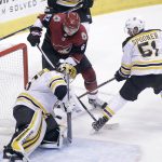 Boston Bruins goalie Anton Khudobin, left, makes a save on the shot by Arizona Coyotes' Lawson Crouse (67) as Boston Bruins' Ryan Spooner skates in to defend during the second period of an NHL hockey game, Saturday, Oct. 14, 2017, in Glendale, Ariz. (AP Photo/Ralph Freso)