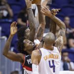 Portland Trail Blazers forward Ed Davis (17) gets sandwiched between Phoenix Suns' Tyson Chandler (4) and Marquese Chriss (0) while going for a rebound during the first half of an NBA preseason basketball game Wednesday, Oct. 11, 2017, in Phoenix. (AP Photo/Darryl Webb)