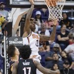 Phoenix Suns forward Marquese Chriss (0) tips in a shot over Portland Trail Blazers' Zach Collins and Ed Davis (17) during the second half of an NBA preseason basketball game Wednesday, Oct. 11, 2017, in Phoenix. (AP Photo/Darryl Webb)