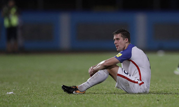 United States' Matt Besler, squats on the pitch after losing 2-1 against Trinidad and Tobago during...