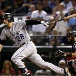 Colorado Rockies' Nolan Arenado follows through on a base hit against the Arizona Diamondbacks during the fourth inning of the National League wild-card playoff baseball game, Wednesday, Oct. 4, 2017, in Phoenix. (AP Photo/Ross D. Franklin)