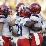 Arizona running back J.J. Taylor (21) is hugged by teammates after scoring on a rushing touchdown against California during the first half of an NCAA college football game Saturday, Oct. 21, 2017, in Berkeley, Calif. (AP Photo/Marcio Jose Sanchez)