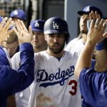 Los Angeles Dodgers' Chris Taylor celebrates in the dugout after scoring on a hit by Justin Turner during the fourth inning of Game 1 of the baseball team's National League Division Series against the Arizona Diamondbacks in Los Angeles, Friday, Oct. 6, 2017. (AP Photo/Jae C. Hong)
