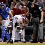 Arizona Diamondbacks' Christian Walker looks down after being hit in the helmet by a pitch as Los Angeles Dodgers catcher Austin Barnes and umpire Gerry Davis check on him during the sixth inning of game 3 of baseball's National League Division Series, Monday, Oct. 9, 2017, in Phoenix. (AP Photo/Rick Scuteri)