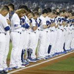 Members of the Los Angeles Dodgers participate in a moment of silence for the victims of the Las Vegas shootings, before Game 1 of the baseball team's National League Division Series against the Arizona Diamondbacks in Los Angeles, Friday, Oct. 6, 2017. (AP Photo/Jae C. Hong)