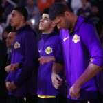 Los Angeles Lakers guard Lonzo Ball, center, locks arms with teammates during the national anthem prior to an NBA basketball game against the Phoenix Suns, Friday, Oct. 20, 2017, in Phoenix. (AP Photo/Matt York)
