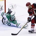 Dallas Stars goalie Ben Bishop (30) makes a sliding save as Arizona Coyotes center Derek Stepan, right, tries to take a shot during the second period of an NHL hockey game Thursday, Oct. 19, 2017, in Glendale, Ariz. (AP Photo/Ross D. Franklin)