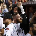 Arizona Diamondbacks' Archie Bradley, center, celebrate his two-run triple against the Colorado Rockies during the seventh inning of the National League wild-card playoff baseball game, Wednesday, Oct. 4, 2017, in Phoenix. (AP Photo/Ross D. Franklin)
