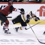 Boston Bruins' Brad Marchand (63) loses control of the puck as he he is checked from behind by Arizona Coyotes' Christian Dvorak during the second period of an NHL hockey game, Saturday, Oct. 14, 2017, in Glendale, Ariz. (AP Photo/Ralph Freso)