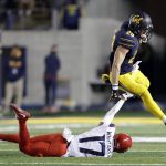 California running back Patrick Laird (28) leaps over Arizona cornerback Jace Whittaker (17) during the second half of an NCAA college football game Saturday, Oct. 21, 2017, in Berkeley, Calif. Arizona won 45-44 in two overtimes. (AP Photo/Marcio Jose Sanchez)