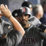 Arizona Diamondbacks' J.D. Martinez celebrates in the dugout after his home run against the Los Angeles Dodgers during the sixth inning of Game 1 of a baseball National League Division Series in Los Angeles, Friday, Oct. 6, 2017. (AP Photo/Mark J. Terrill)