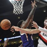 Portland Trail Blazers center Jusuf Nurkic passes the ball past Phoenix Suns forward Marquese Chriss during the first half of an NBA basketball preseason game in Portland, Ore., Tuesday, Oct. 3, 2017. (AP Photo/Steve Dykes)