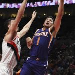 Phoenix Suns guard Devin Booker drives to the basket on Portland Trail Blazers center Zach Collins during the second half of an NBA basketball preseason game in Portland, Ore., Tuesday, Oct. 3, 2017. The Suns won 114-112. (AP Photo/Steve Dykes)