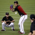 Arizona Diamondbacks shortstop Ketel Marte pretends to hit as Diamondbacks left fielder Kristopher Negron catches  during a workout at Chase Field, Tuesday, Oct. 3, 2017, in Phoenix, as the team gets ready for a National League wild-card playoff baseball game. The Diamondbacks host the Colorado Rockies on Wednesday. (AP Photo/Matt York)