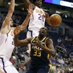 Utah Jazz forward Ekpe Udoh (33) loses control of the ball under the basket as he is guarded by Phoenix Suns' Alex Len, left, and Josh Jackson (20) during the first half of a preseason NBA basketball game, Monday, Oct. 9, 2017, in Phoenix. (AP Photo/Ralph Freso)