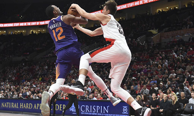 Phoenix Suns forward TJ Warren and Portland Trail Blazers center Zach Collins go after a ball durin...