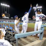 Los Angeles Dodgers' Justin Turner, right, celebrates his three-run home run with manager Dave Roberts at the dugout during the first inning of Game 1 of the baseball team's National League Division Series against the Arizona Diamondbacks in Los Angeles, Friday, Oct. 6, 2017. (AP Photo/Jae C. Hong)