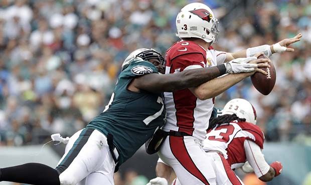 Philadelphia Eagles' Vinny Curry, left, tackles Arizona Cardinals' Carson Palmer during the first h...