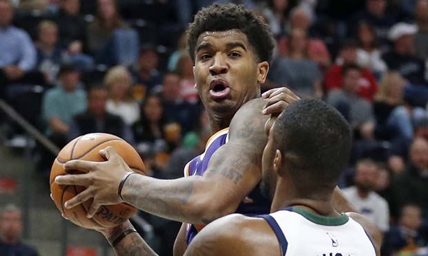 Phoenix Suns forward Marquese Chriss, left, goes to the basket as Utah Jazz forward Derrick Favors ...