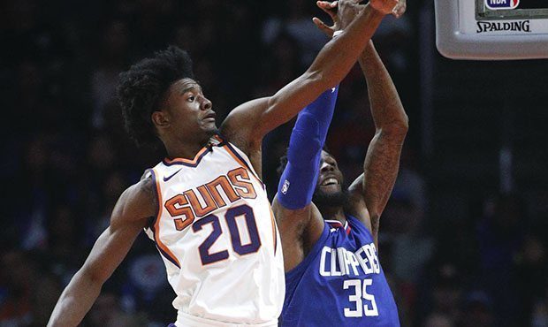Phoenix Suns' Josh Jackson, left, blocks a shot by Los Angeles Clippers' Willie Reed during the fir...