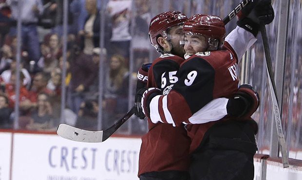 Arizona Coyotes center Clayton Keller (9) celebrates with Jason Demers (55) after scoring a second-...