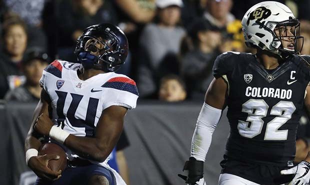 Arizona quarterback Khalil Tate, left, reacts after getting tripped up before reaching the end zone...