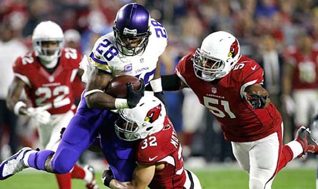 Minnesota Vikings running back Adrian Peterson (28) is tackled by Arizona Cardinals free safety Tyr...