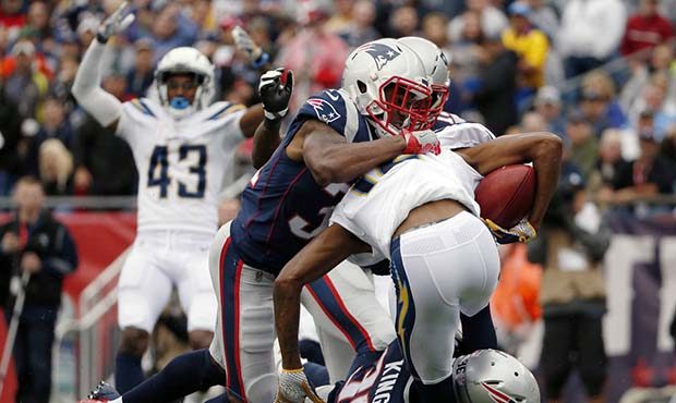New England Patriots' Jonathan Jones top and Brandon King (36) tackle Los Angeles Chargers punt ret...