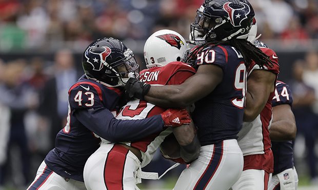 Arizona Cardinals running back Adrian Peterson, center, is wrapped up by Houston Texans defenders C...