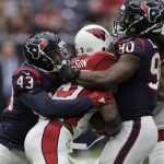 Arizona Cardinals running back Adrian Peterson, center, is wrapped up by Houston Texans defenders Corey Moore (43) and Jadeveon Clowney (90) during the first half of an NFL football game Sunday, Nov. 19, 2017, in Houston. (AP Photo/David J. Phillip)