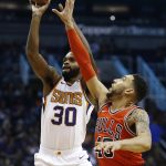 Phoenix Suns guard Troy Daniels (30) gets off a shot as Chicago Bulls forward Denzel Valentine, right, arrives to defend during the first half of an NBA basketball game, Sunday, Nov. 19, 2017, in Phoenix. (AP Photo/Ross D. Franklin)