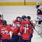 Washington Capitals defenseman John Carlson (74), T.J. Oshie (77), Madison Bowey (22), and others celebrate after Carlson's game winning goal in overtime of an NHL hockey game as Arizona Coyotes goalie Scott Wedgewood (31) skates by at top, Monday, Nov. 6, 2017, in Washington. The Capitals won 3-2 in overtime. (AP Photo/Nick Wass)