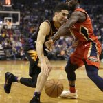 Phoenix Suns guard Devin Booker (1) drives against New Orleans Pelicans guard Jrue Holiday in the second half during an NBA basketball game, Friday, Nov 24, 2017, in Phoenix. (AP Photo/Rick Scuteri)