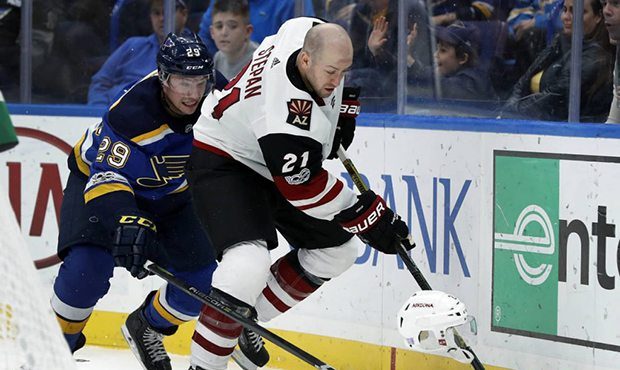 Arizona Coyotes' Derek Stepan (21) loses his helmet while reaching for a loose puck with St. Louis ...