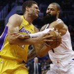 Los Angeles Lakers center Brook Lopez, left, grimaces as he is fouled while going up for a shot by Phoenix Suns center Tyson Chandler, right, during the first half of an NBA basketball game Monday, Nov. 13, 2017, in Phoenix. (AP Photo/Ross D. Franklin)