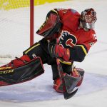 Calgary Flames goalie Mike Smith clears the puck against the Arizona Coyotes during the second period of an NHL hockey game Thursday, Nov. 30, 2017, in Calgary, Alberta. (Lyle Aspinall/The Canadian Press via AP)