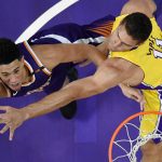 Phoenix Suns guard Devin Booker, left, shoots as Los Angeles Lakers center Brook Lopez defends during the first half of an NBA basketball game, Friday, Nov. 17, 2017, in Los Angeles. (AP Photo/Mark J. Terrill)