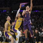 Phoenix Suns guard Devin Booker, right, shoots as Los Angeles Lakers guard Lonzo Ball, left, and guard Jordan Clarkson defend during the second half of an NBA basketball game, Friday, Nov. 17, 2017, in Los Angeles. The Suns won 122-113. (AP Photo/Mark J. Terrill)