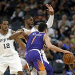 San Antonio Spurs Brandon Paul draws a charge from Phoenix Suns' Devin Booker during the first half of an NBA game on Sunday, Nov. 5, 2017 in San Antonio. (AP Photo/Ronald Cortes)