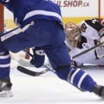 Arizona Coyotes goalie Antti Raanta (32) reaches out to make a save as Toronto Maple Leafs center Mitchell Marner tries to corral the puck during first-period NHL hockey game action in Toronto, Monday, Nov. 20, 2017. (Nathan Denette/The Canadian Press via AP)