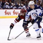 Arizona Coyotes center Brad Richardson (15) and Winnipeg Jets center Mark Scheifele (55) battle for the puck during the first period of an NHL hockey game Saturday, Nov. 11, 2017, in Glendale, Ariz. (AP Photo/Ross D. Franklin)