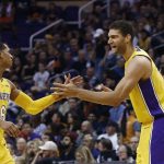 Los Angeles Lakers center Brook Lopez, right, slaps hands with guard Jordan Clarkson (6) after Clarkson scored against the Phoenix Suns. as Lakers' Corey Brewer, left, arrives to celebrate as well during the second half of an NBA basketball game Monday, Nov. 13, 2017, in Phoenix. The Lakers won 100-93. (AP Photo/Ross D. Franklin)