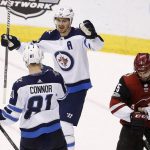 Winnipeg Jets left wing Kyle Connor (81) celebrates his goal against the Arizona Coyotes with Jets center Mark Scheifele (55) as Coyotes' Brad Richardson (15) skates past during the third period of an NHL hockey game Saturday, Nov. 11, 2017, in Glendale, Ariz. The Jets defeated the Coyotes 4-1. (AP Photo/Ross D. Franklin)