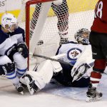 Winnipeg Jets defenseman Tyler Myers (57) grimaces as he falls to the ice due to injury after helping Jets goalie Steve Mason, right, make a save against the Arizona Coyotes during the third period of an NHL hockey game Saturday, Nov. 11, 2017, in Glendale, Ariz. The Jets defeated the Coyotes 4-1. (AP Photo/Ross D. Franklin)