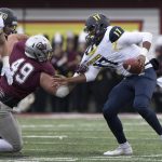 Northern Arizona quarterback Stone Smart (17) is pulled down for a sack by Montana defensive tackle Jesse Sims (49)in the second half of an NCAA college football game Saturday, Nov. 4, 2017, in Missoula, Mont. (AP Photo/Patrick Record)