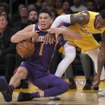 Phoenix Suns guard Devin Booker, left, and Los Angeles Lakers guard Kentavious Caldwell-Pope compete for a loose ball during the first half of an NBA basketball game, Friday, Nov. 17, 2017, in Los Angeles. (AP Photo/Mark J. Terrill)