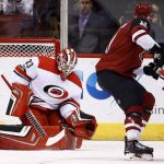 Carolina Hurricanes goalie Scott Darling (33) makes a save on a shot by Arizona Coyotes left wing Brendan Perlini, right, during the first period of an NHL hockey game Saturday, Nov. 4, 2017, in Glendale, Ariz. (AP Photo/Ross D. Franklin)