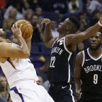 Brooklyn Nets guard Caris LeVert (22) collides with Phoenix Suns forward Jared Dudley, left, as Nets' DeMarre Carroll (9) looks on during the first half of an NBA basketball game Monday, Nov. 6, 2017, in Phoenix. (AP Photo/Ross D. Franklin)